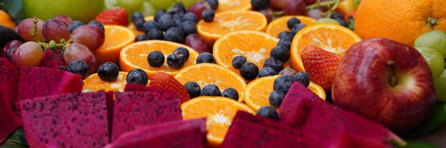 Platter of cut fresh fruit: oranges, blueberries, grapes and strawberries