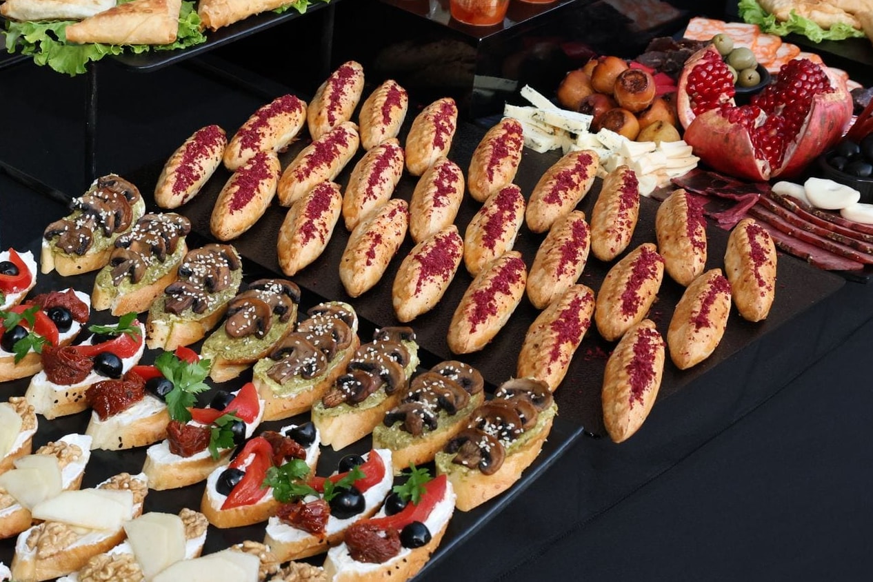 Cocktail table: canapés, puff pastries, cheeses and pomegranate