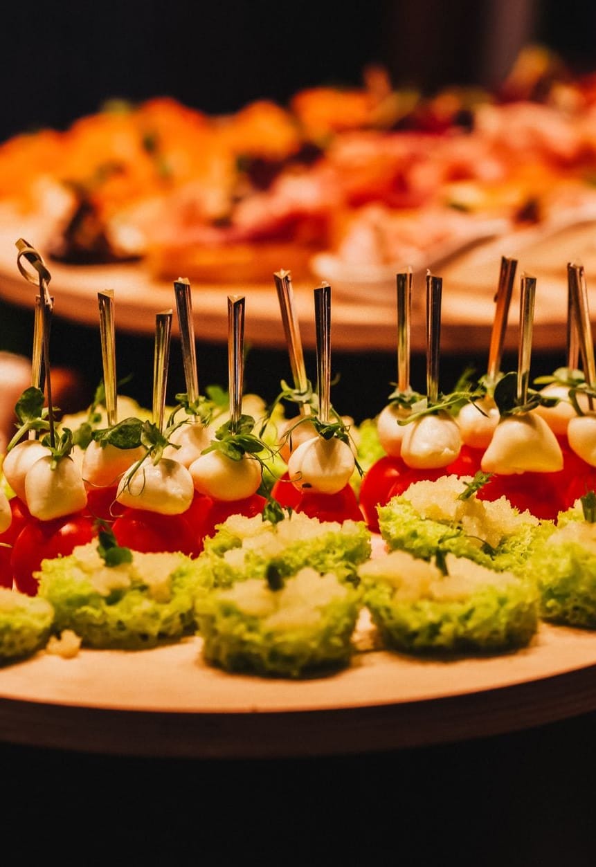 Tomato and mozzarella bites on wooden platters, at an evening event